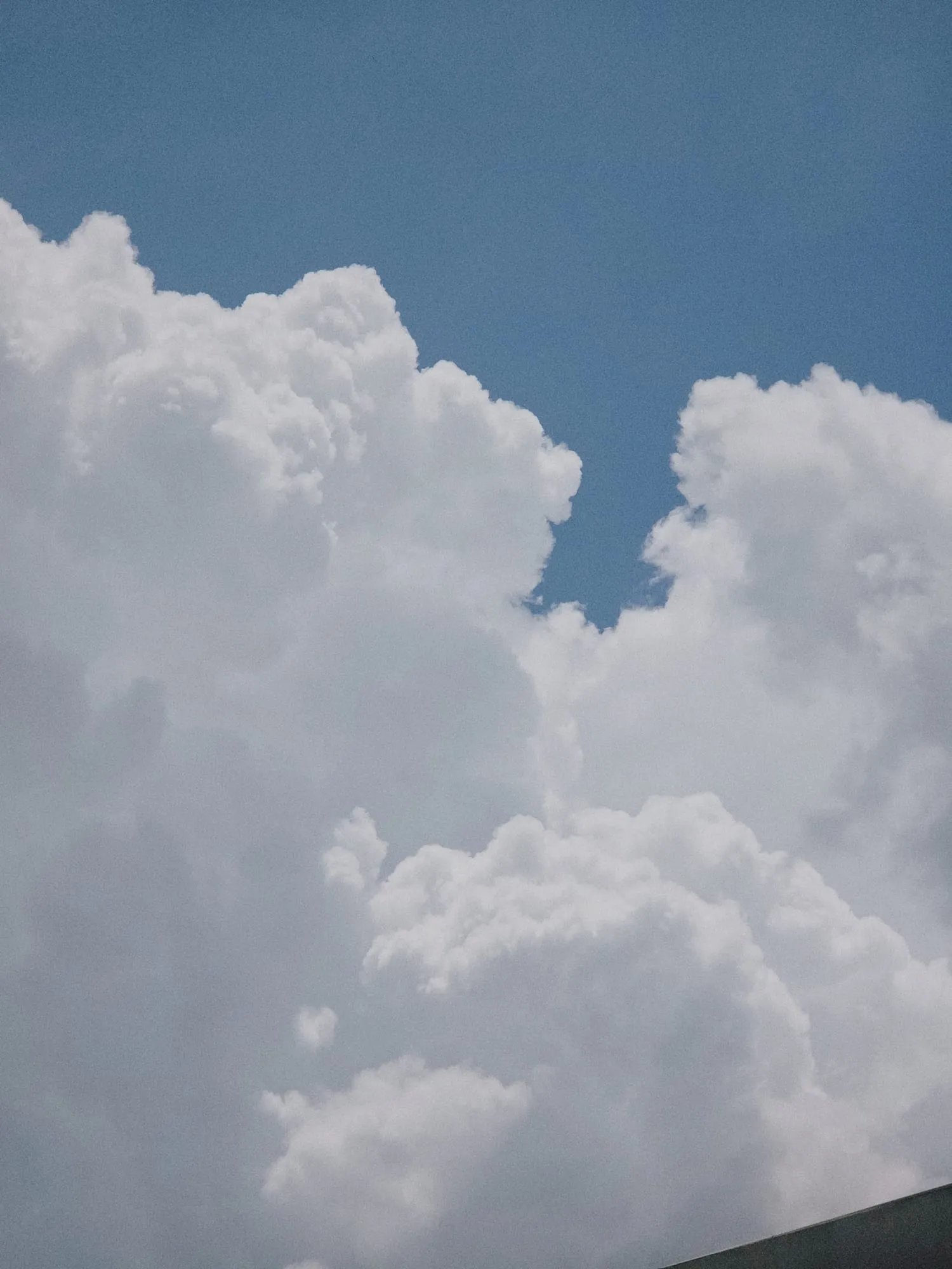 Tall white clouds against a blue sky