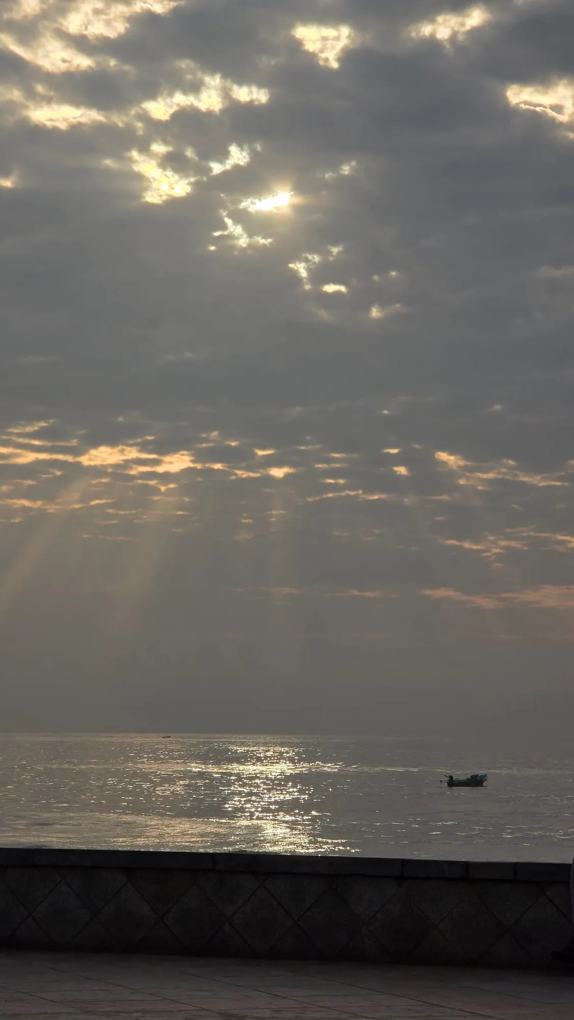 Sun rays breaking through clouds over the sea
